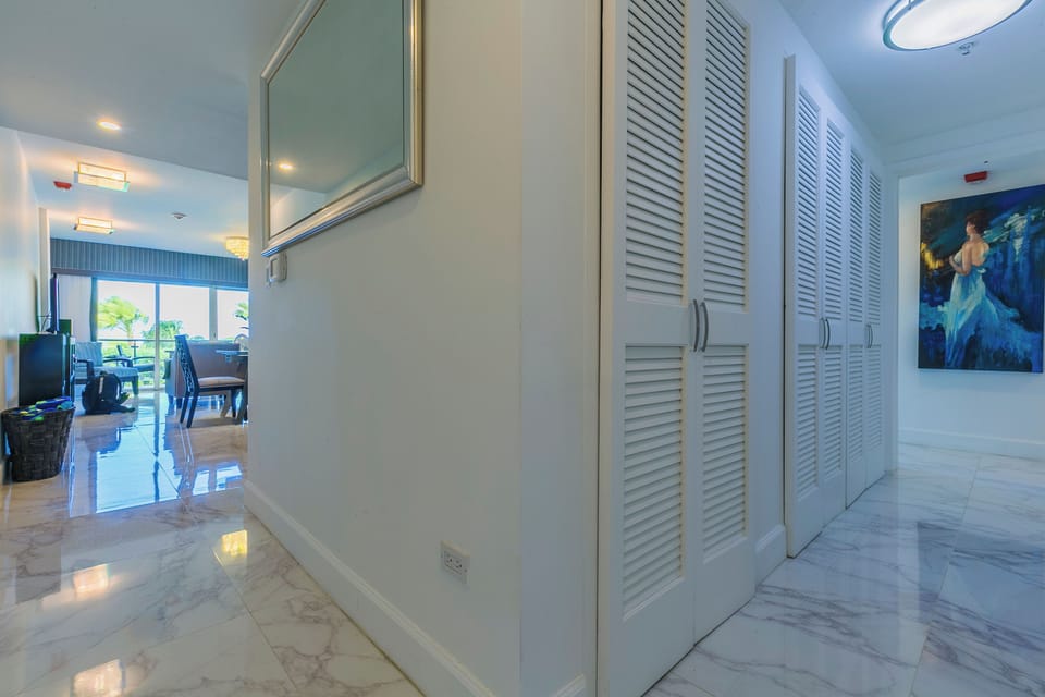 Step into your bright, spacious entryway with polished marble floors and generous storage, leading to inviting living spaces with natural light and ocean breezes ahead.