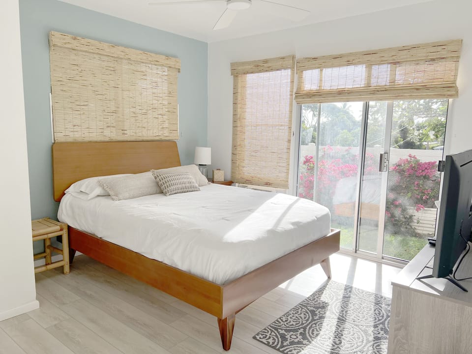 Master bedroom with flat-screen Smart TV and sliding doors to private outdoor 