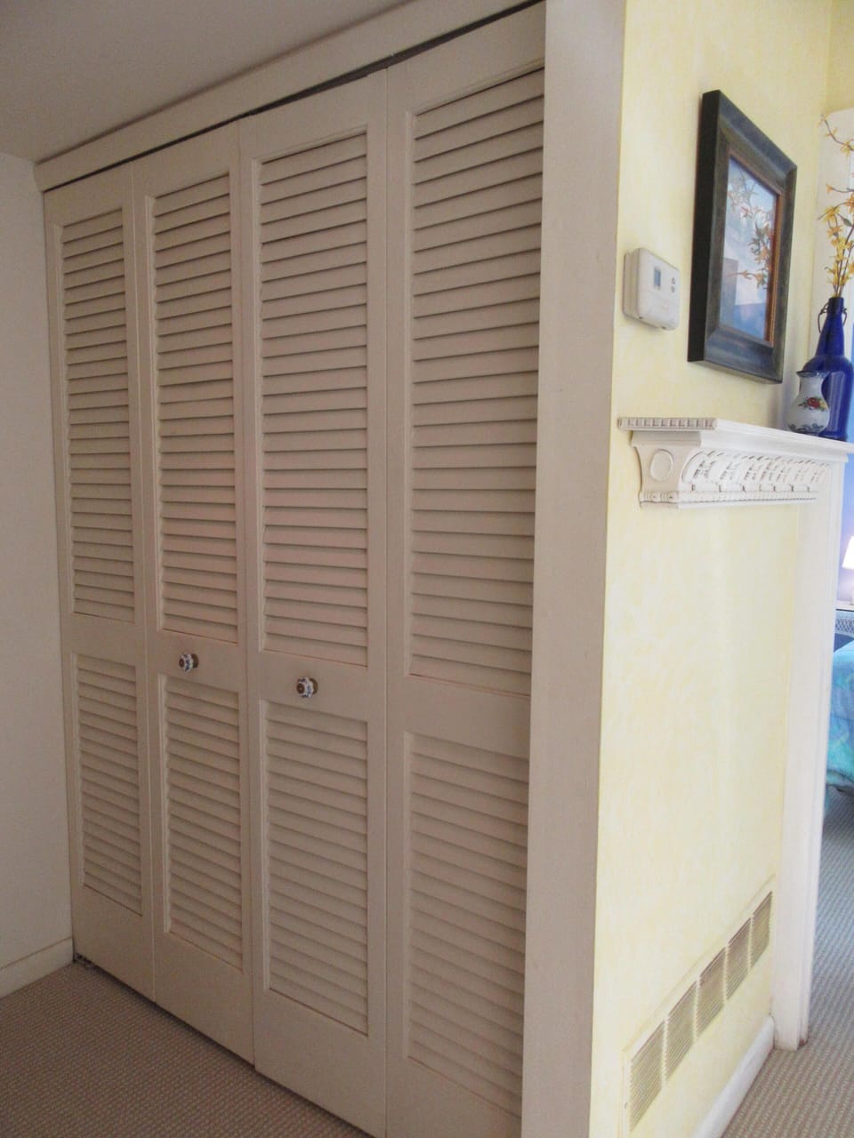 Full-size washer and dryer behind bi-fold doors.