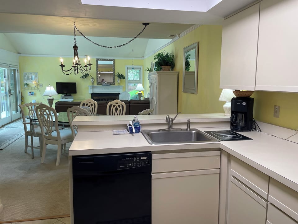 Kitchen sink w/ dishwasher & coffeemaker overlooks dining & Livingroom
