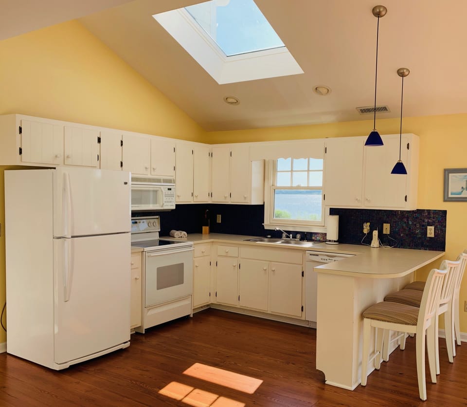 Gathering Room full kitchen with snack bar & entrance to rear deck and lawn