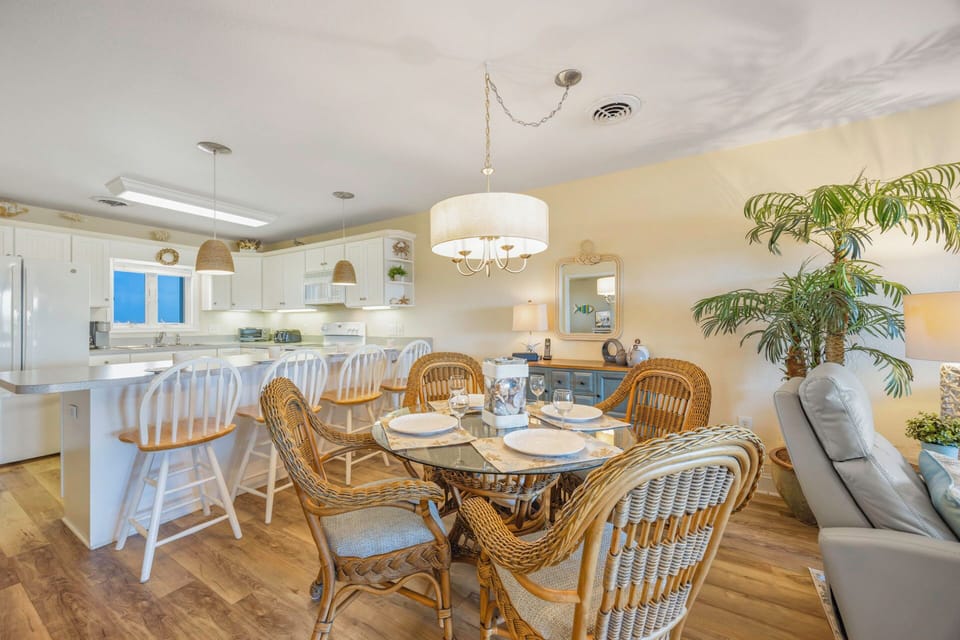 Enjoy meals together in your bright, open dining area with wicker chairs and coastal charm flowing seamlessly into the fully equipped kitchen.