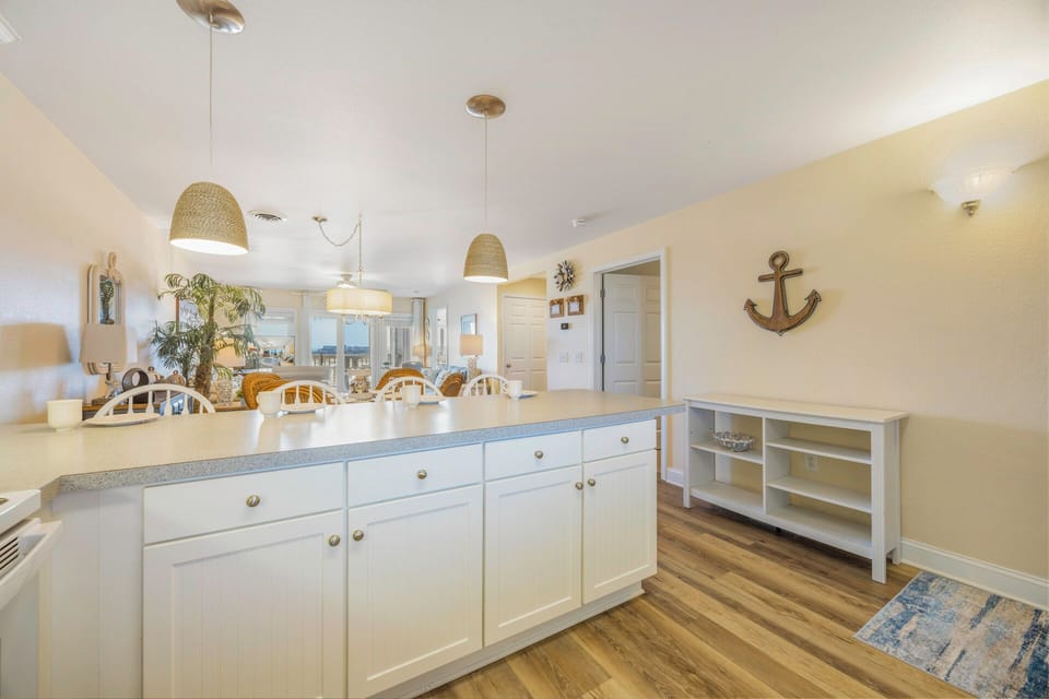 Your coastal-inspired kitchen features ample counter space, pendant lighting, and nautical touches perfect for preparing memorable meals together.