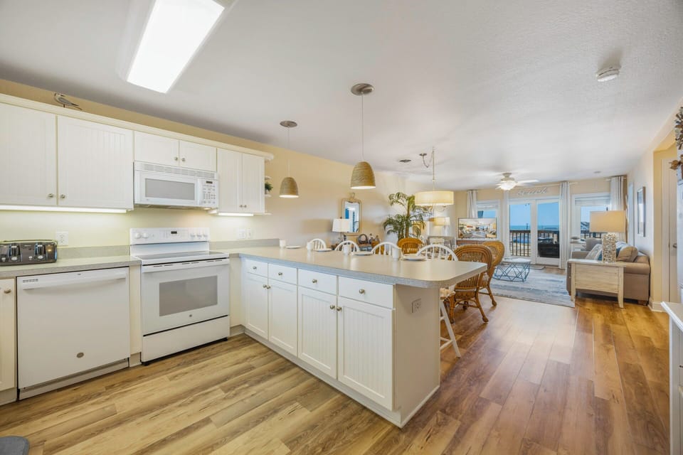 Your bright open kitchen flows seamlessly into dining and living areas, with modern appliances and warm wood floors throughout.