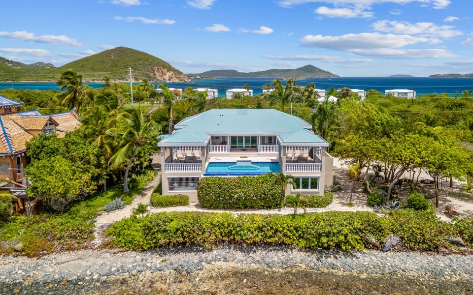 Open-air living with pool, deck, and beach all in one space