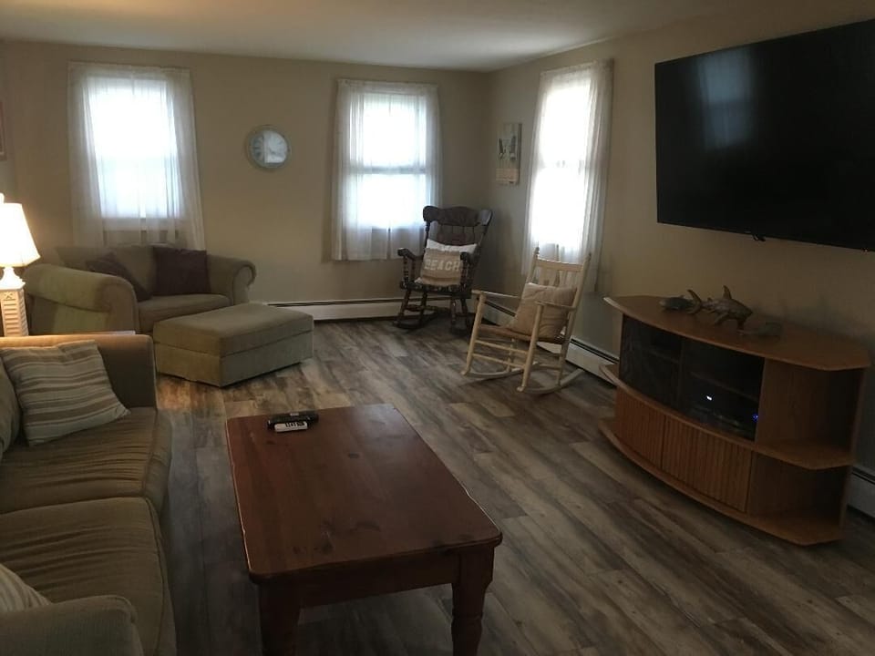 Spacious living room with new flooring and 65 inch TV