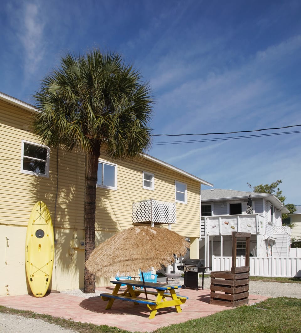 Outdoor patio with picnic table, lounge chairs, grill and fire table.