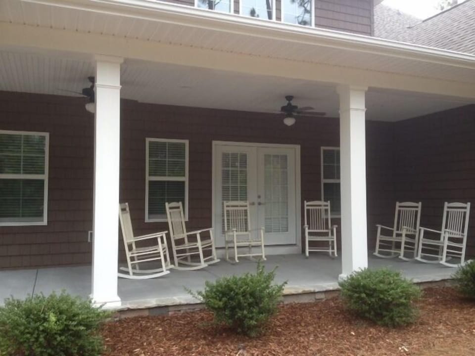 Back porch with rocking chairs and gas grill
