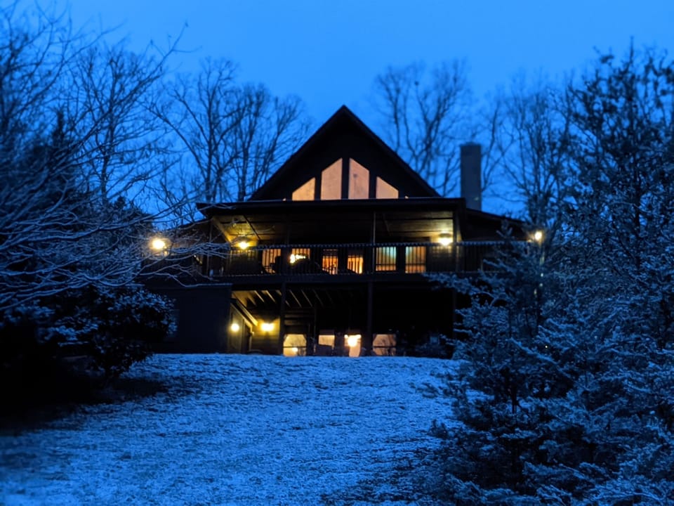 - Snow-kissed cabin glowing under twilight sky   - Cozy mountain retreat surrounded by peaceful woods   - Perfect winter escape with warm lights and rustic charm