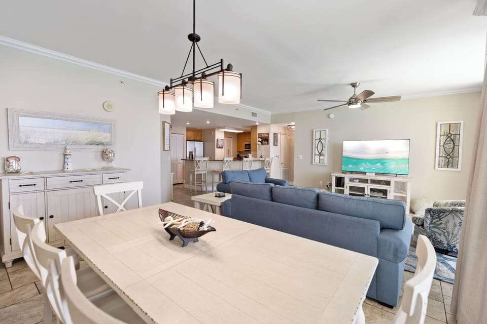 Relax in your stylish open-plan space with a cozy sectional sofa, modern dining table, and fully equipped kitchen.