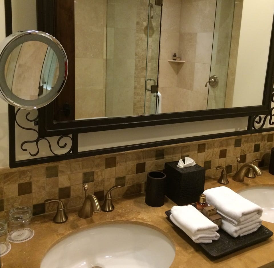 Full bathroom with two sinks, bath tub and shower, look in the mirror.