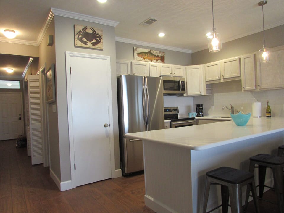 Kitchen featuring brand new appliances, cabinets, and quartz countertop.