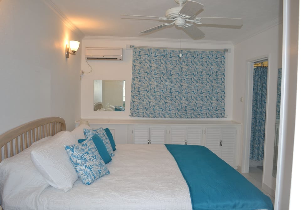 Bedroom, with window blind down, and door to bathroom