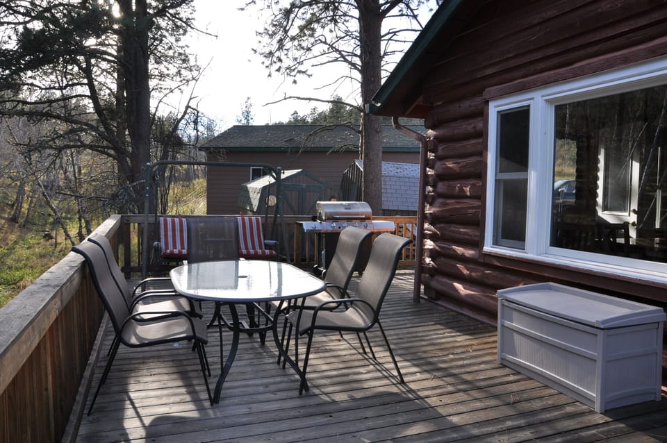 Deck with grill, swing, and table for outdoor eating