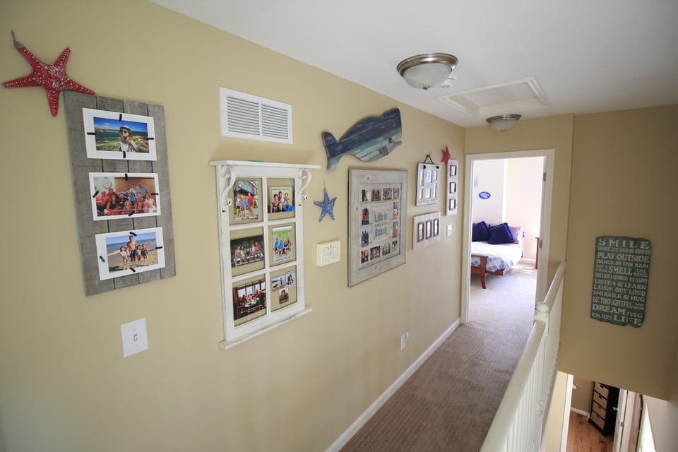 Upstairs hallway - Beach Family Photo Wall-Pictures previous guests have shared!