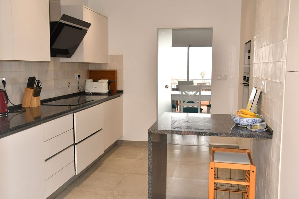 Sleek new kitchen with door to the dining area of the living room