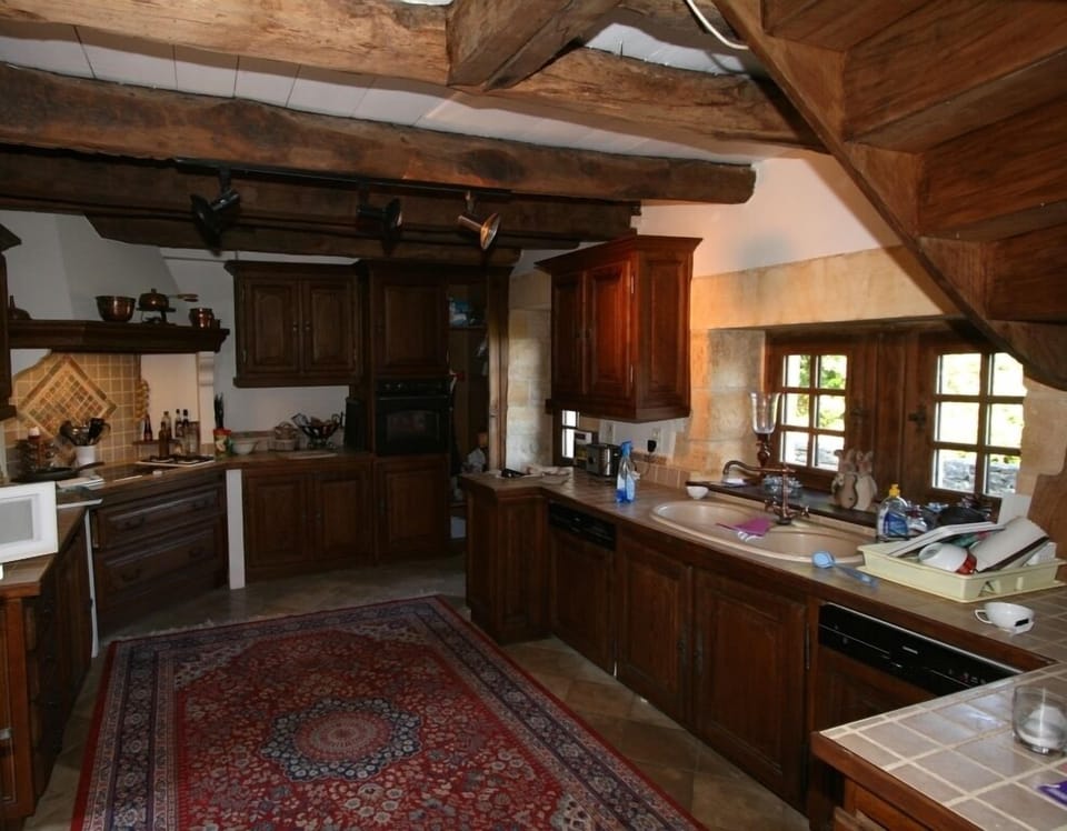 large country style kitchen has two dishwashers and doors leading out to terrace