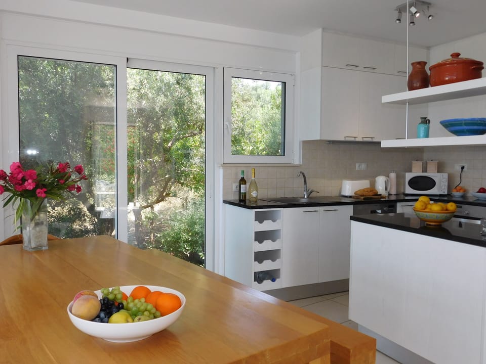 13 Alexandria villa kitchen and dining area with doors to the barbeque.