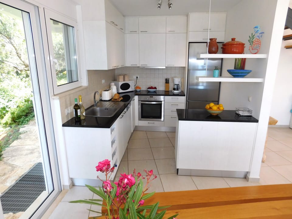14 Alexandria villa kitchen area with doors to the barbeque.