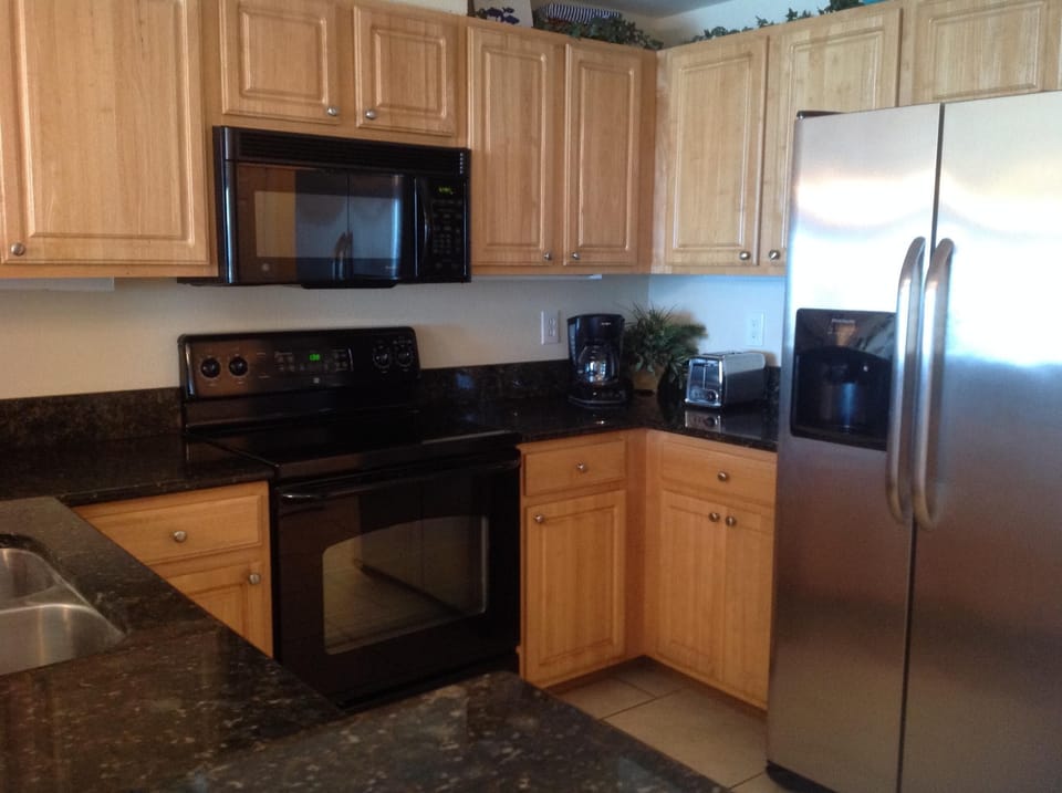 Kitchen with granite counters.KCup and regular coffee maker.
