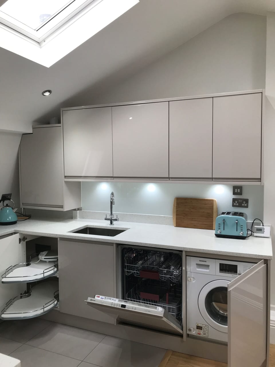 Cashmere gloss handle-less kitchen doors hide integrated appliances