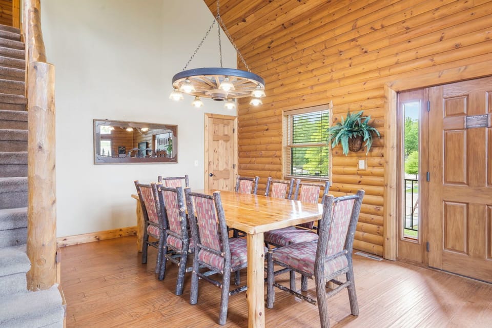 Dining room with 8 Custom log chairs, custom table and wagon wheel chandelier!