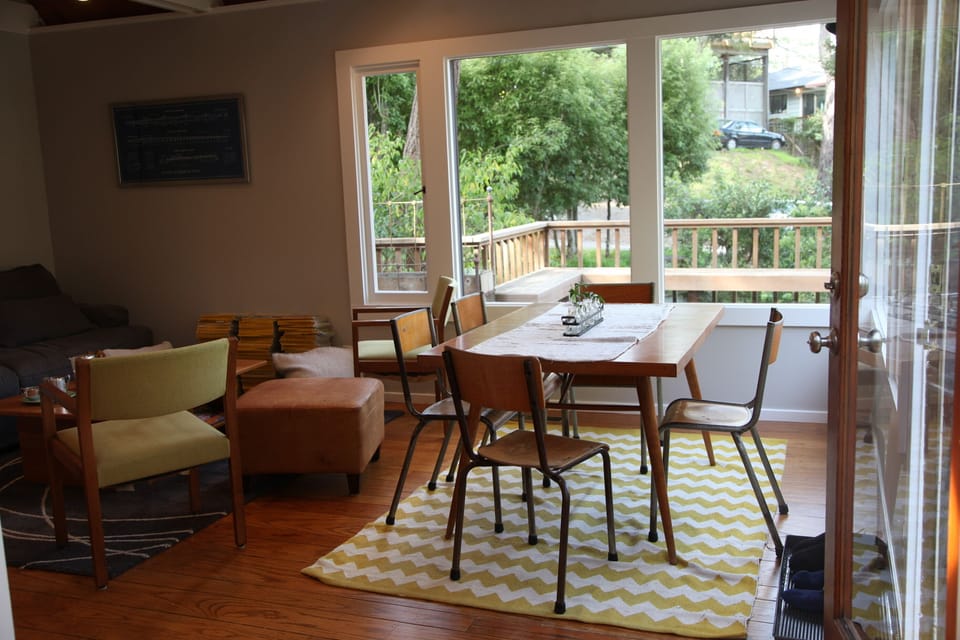 Dining area surrounded overlooking deck, trees and cascading sunshine