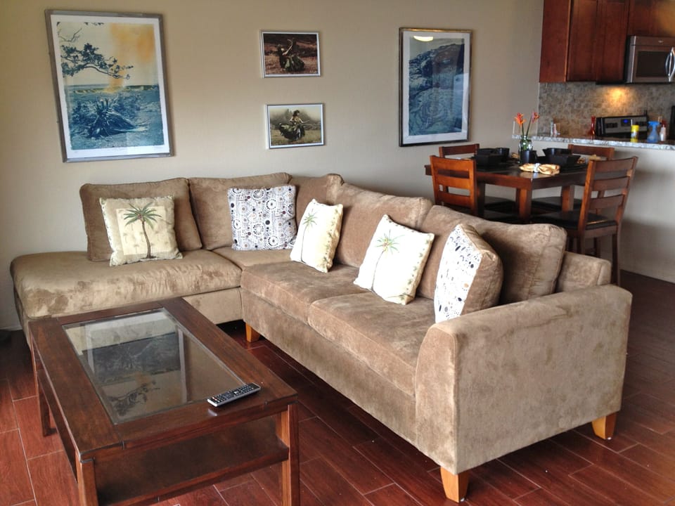 Enjoy the ocean view from living room with sectional sofa tile floor ceiling fan