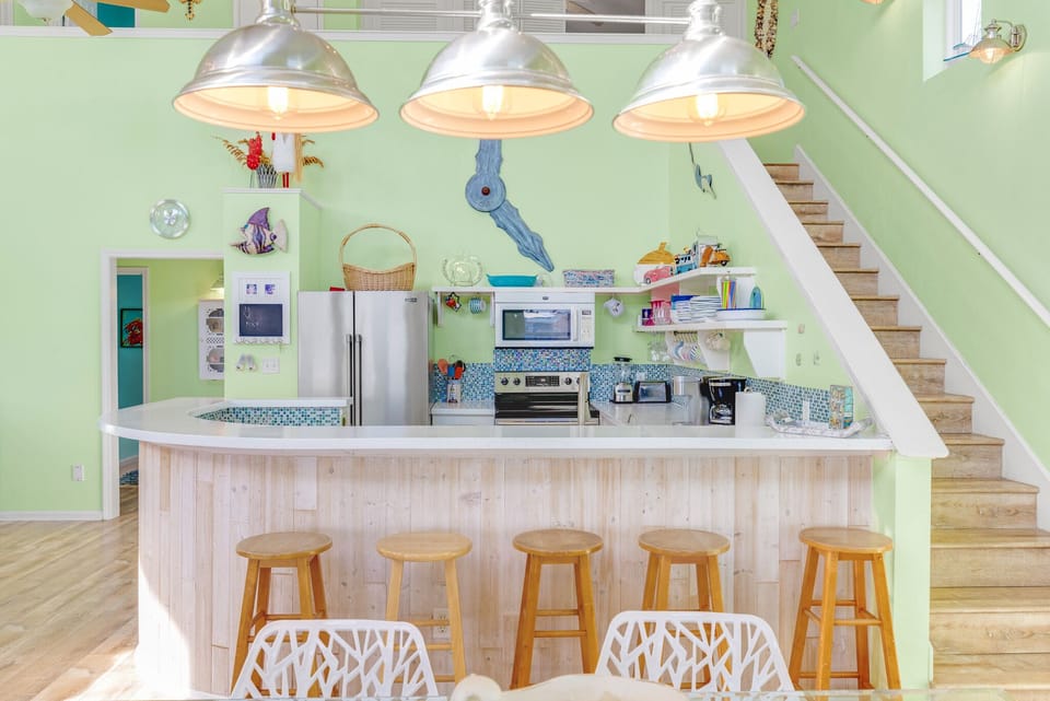 Kitchen with wrap-around bar and stools for extra seating.
