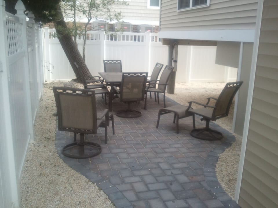shaded backyard patio furniture on pavers