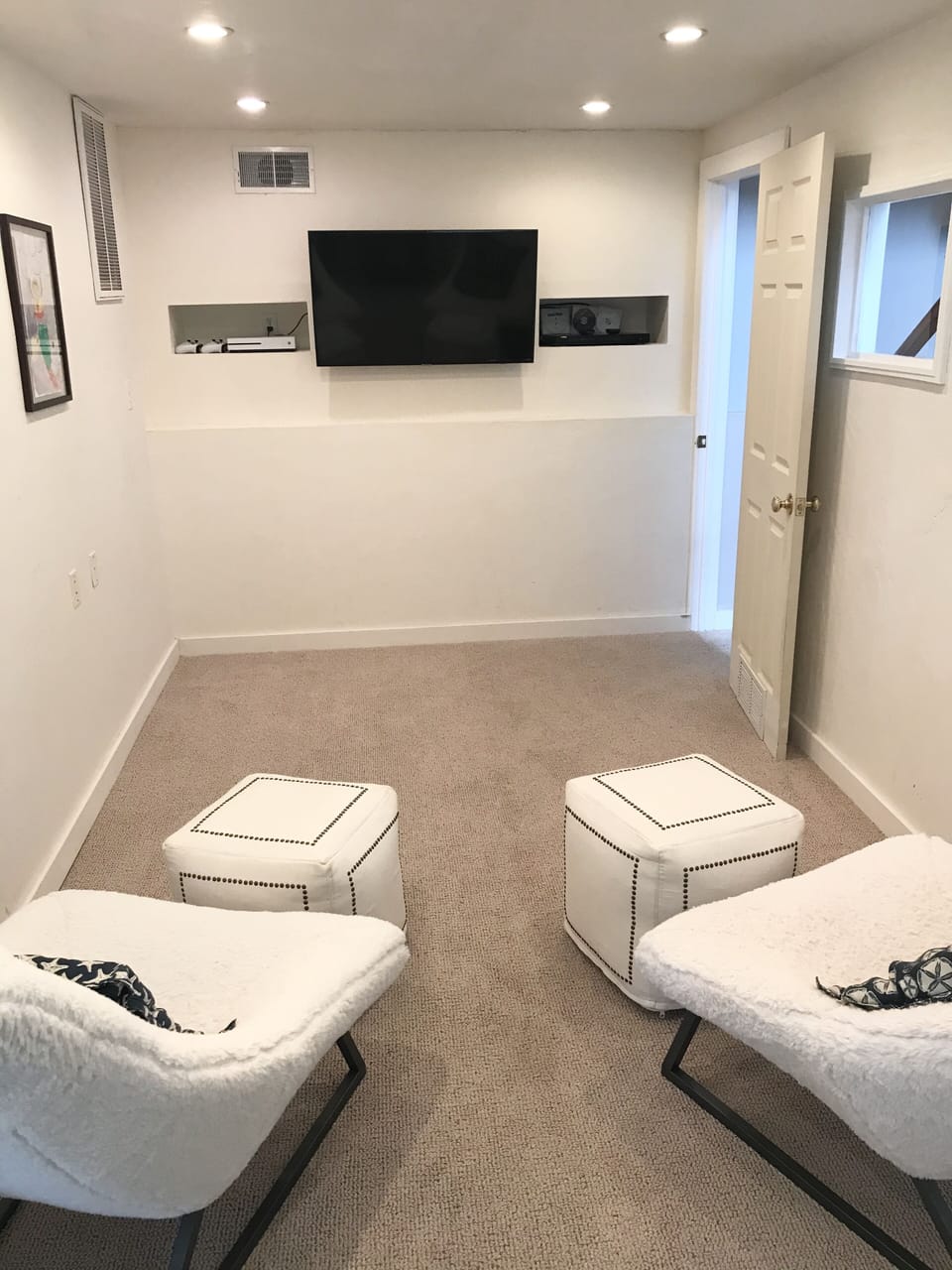 Entertainment room with flat screen, game system and roll-out queen bed