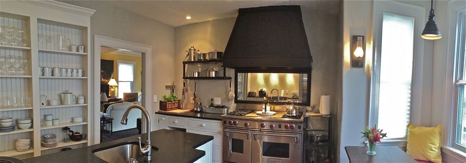 Cheerful kitchen with 48" Wolf range, Sub Zero refrigerators, bay window seats