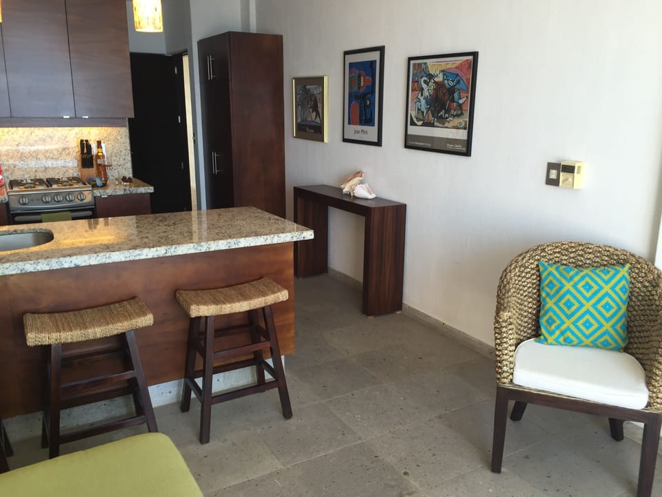 Living area with bar area, kitchen and hallway to bathroom and bedroom