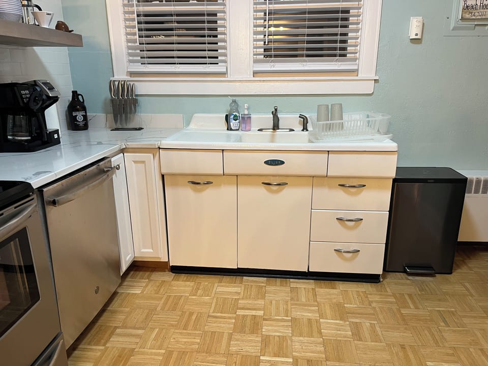 Fully stocked kitchen with modern appliances but original, vintage metal cabinet