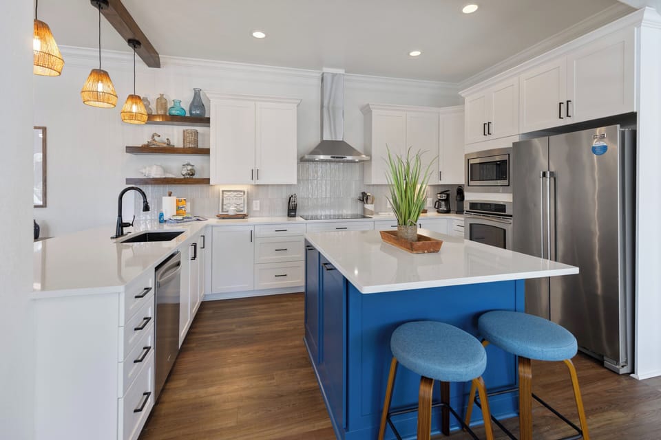 Your gourmet kitchen features a vibrant blue island, perfect for morning coffee or evening gatherings.