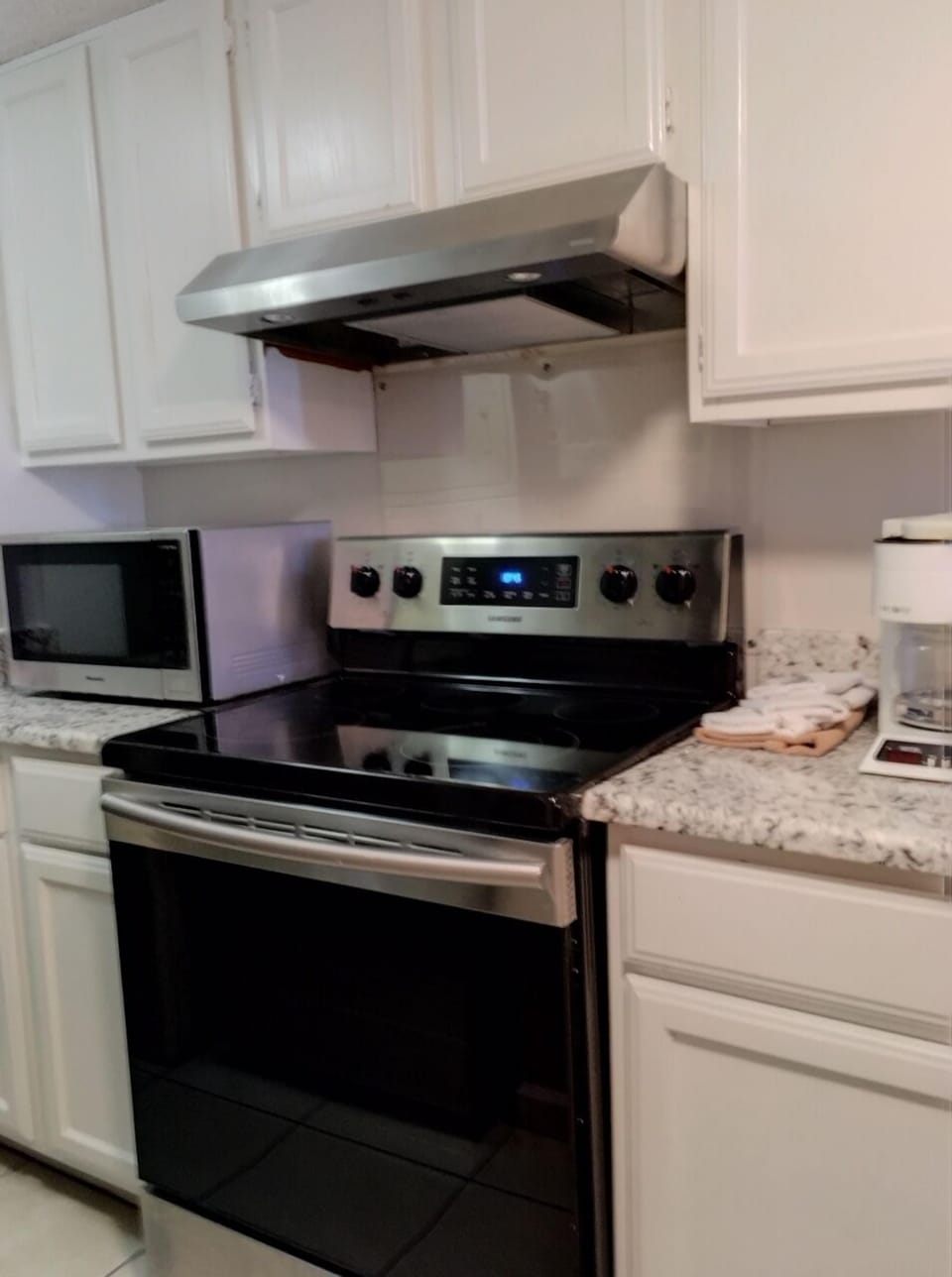 Stainless steel appliances, granite and freshly painted cabinets