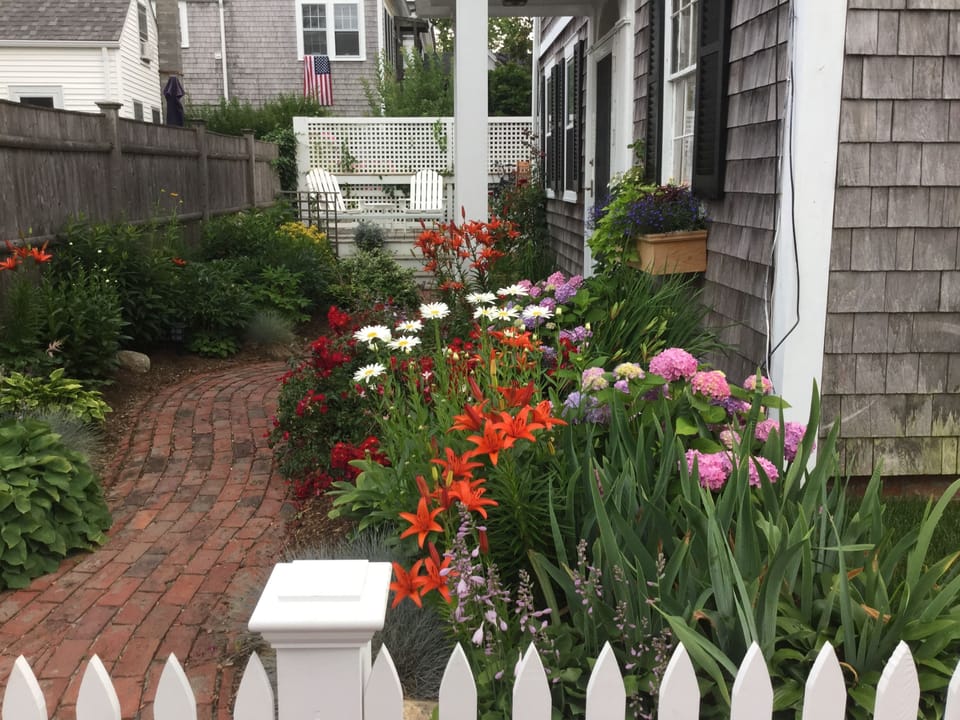 Side of house with Adirondack chairs on back deck
