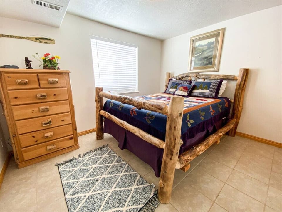 Cheerful bedroom with rustic log bed and charming mountain decor for a peaceful night’s rest.