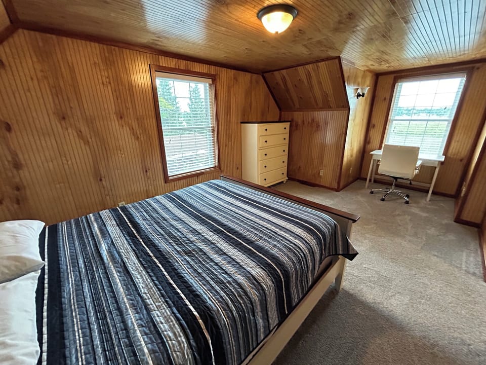 Upstairs bedroom with queen bed.  Desk and chair with lake views.