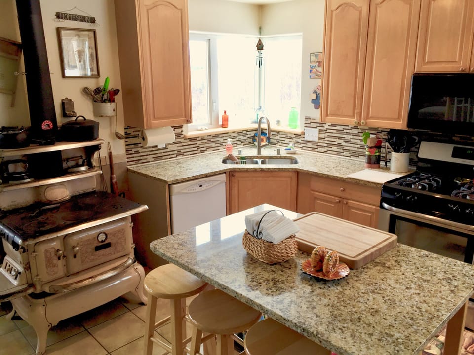 Fully equipped kitchen has working antique wood-cook stove, stove , microwave