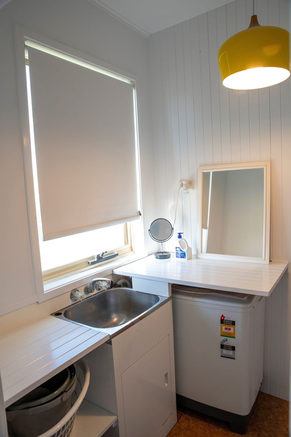 Laundry with washing machine, washing line, pegs and some detergents provided.