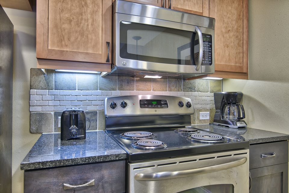 Kitchen - Electric stove and above range microwave.