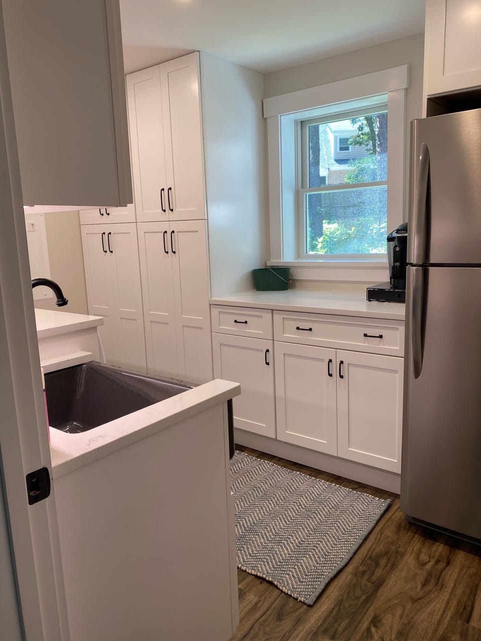 Large laundry room with extra refrigerator and storage