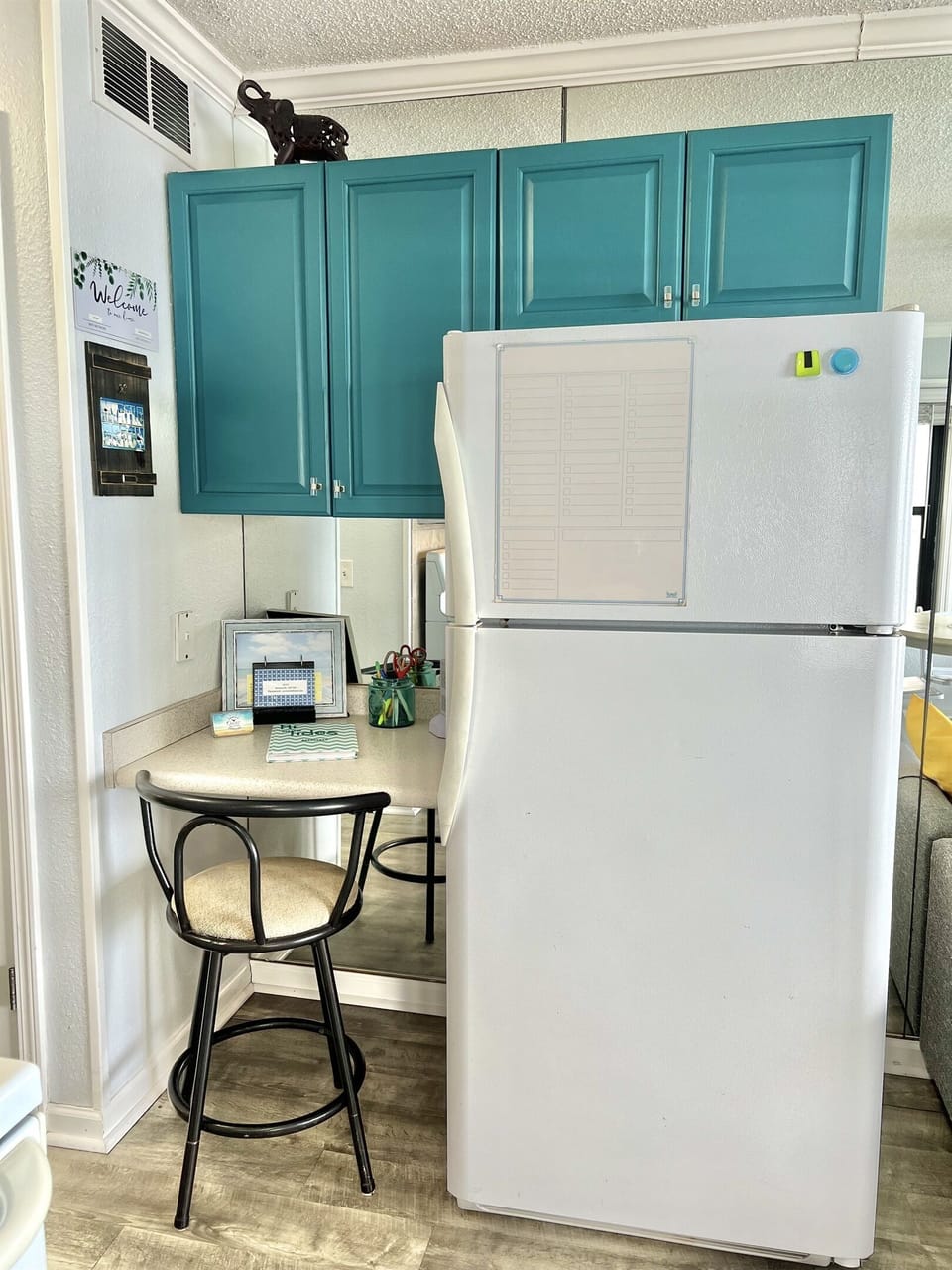 Small desk area and charging station by the refrigerator