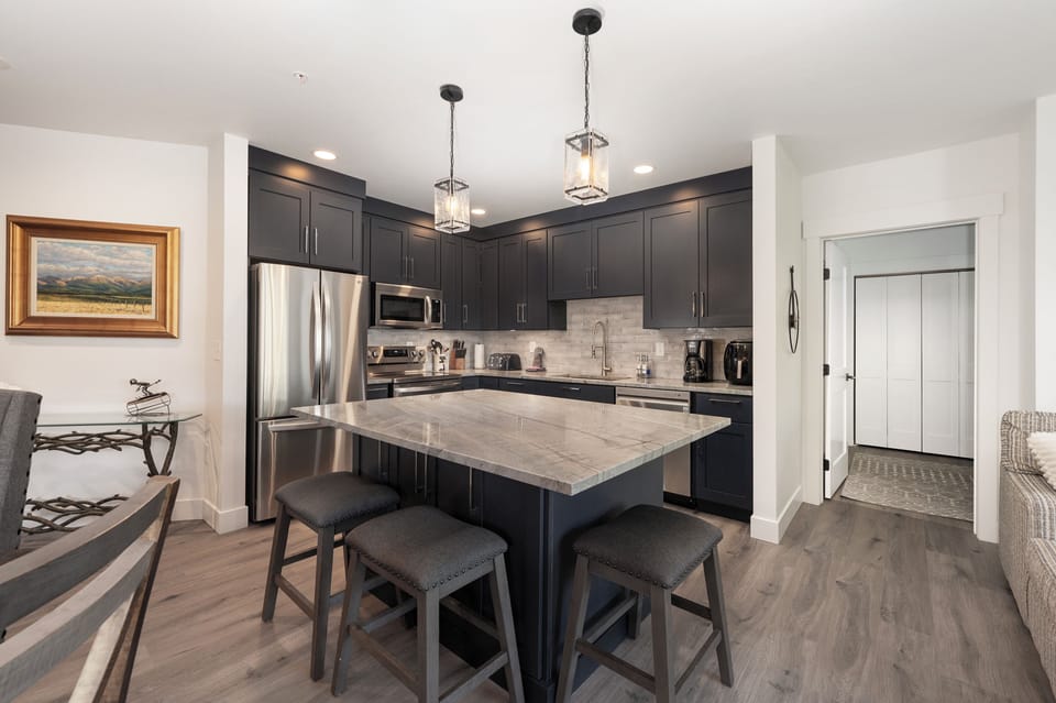 Kitchen offers stainless steel appliances, and additional seating at the island.