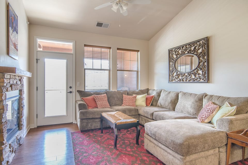 Living Area - Large sectional with chaise lounge, fireplace, flat screen TV, and access to private balcony.