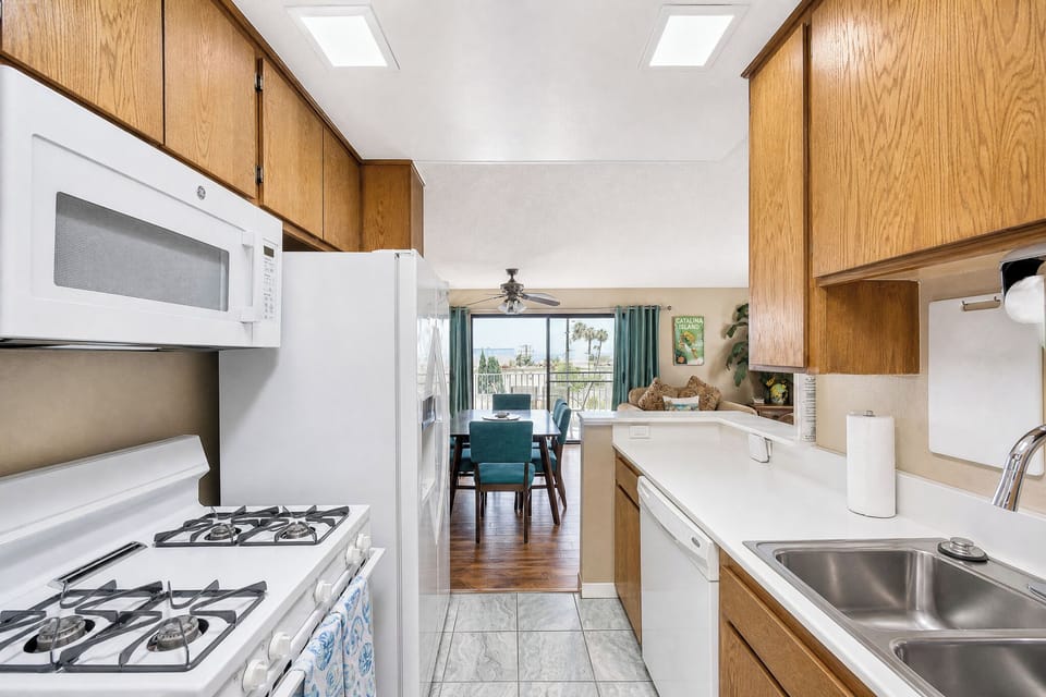 Your fully-equipped kitchen opens seamlessly to bright, airy living and dining spaces. Skylights and fresh natural light set the scene for easy meal prep and relaxed coastal living.