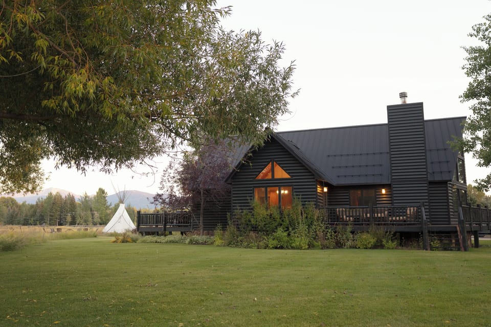 Your own mountain retreat awaits with this stunning log cabin surrounded by rolling meadows and towering peaks. Step onto your private deck as evening falls, breathing in the crisp air while warm light glows from within.