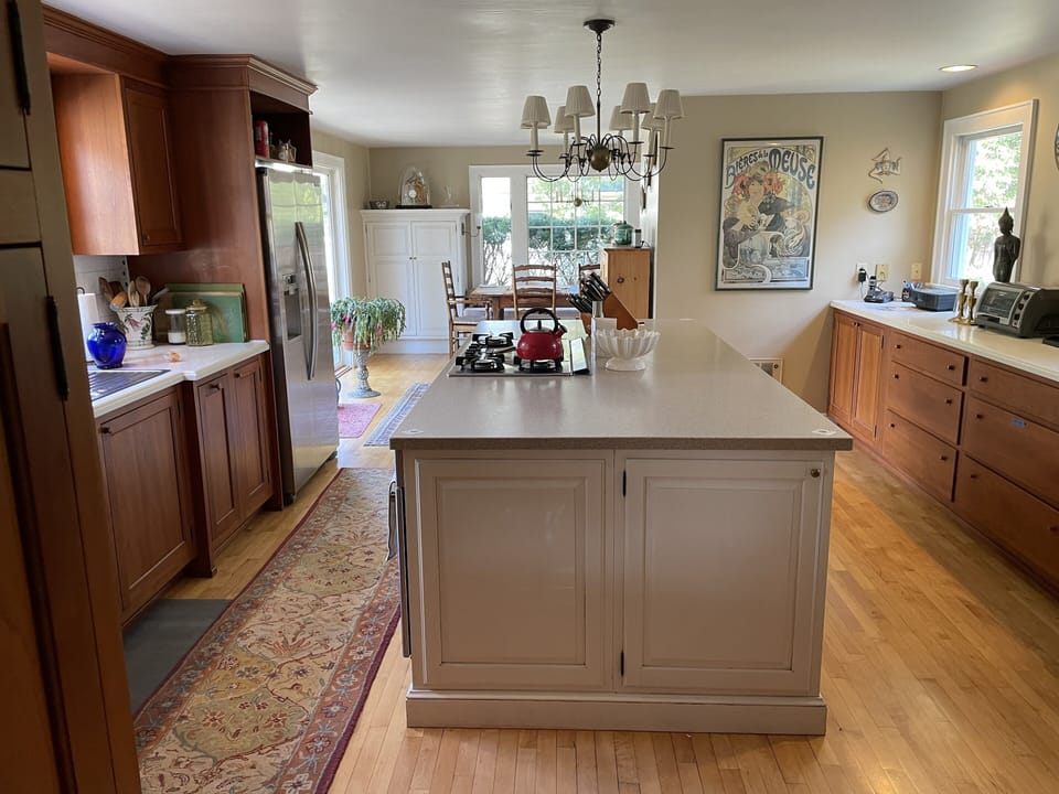 Huge kitchen with center island, farmhouse table, and opening to patio/lawn/pool