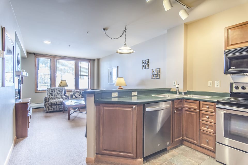 Kitchen - Double sinks, glass top range, and a variety of cooking utensils.